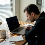 Man trading cryptocurrency at home desk