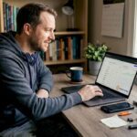 Man updating crypto tracker in home office