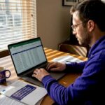 Man updating crypto tax records at home